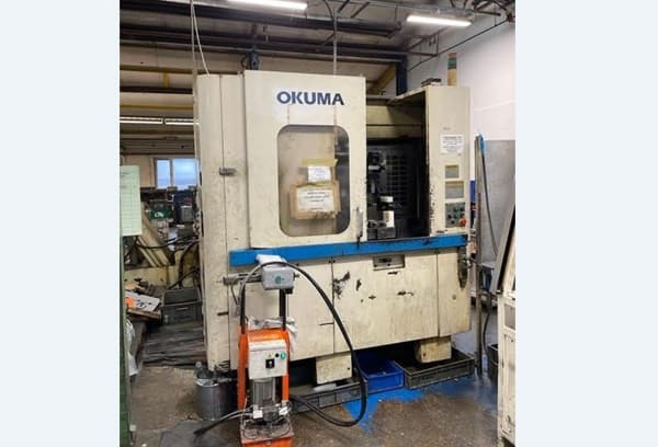 Okuma MA-40HA Twin Pallet Horizontal Machining Centre in a clean workshop environment, featuring a beige and blue body with a front viewing window and integrated control panel.